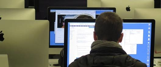 Behind view of a man typing on his computer