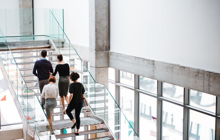 Employees walking up the stairs in an office building