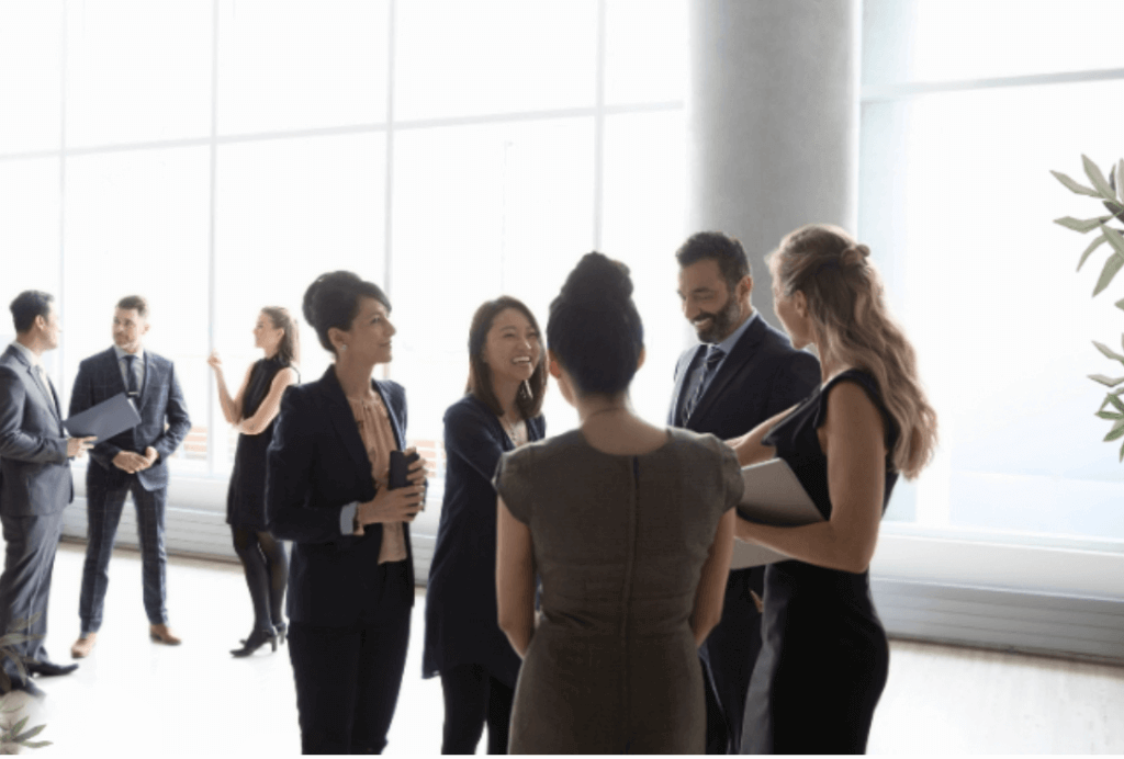 employees standing around talking in a room