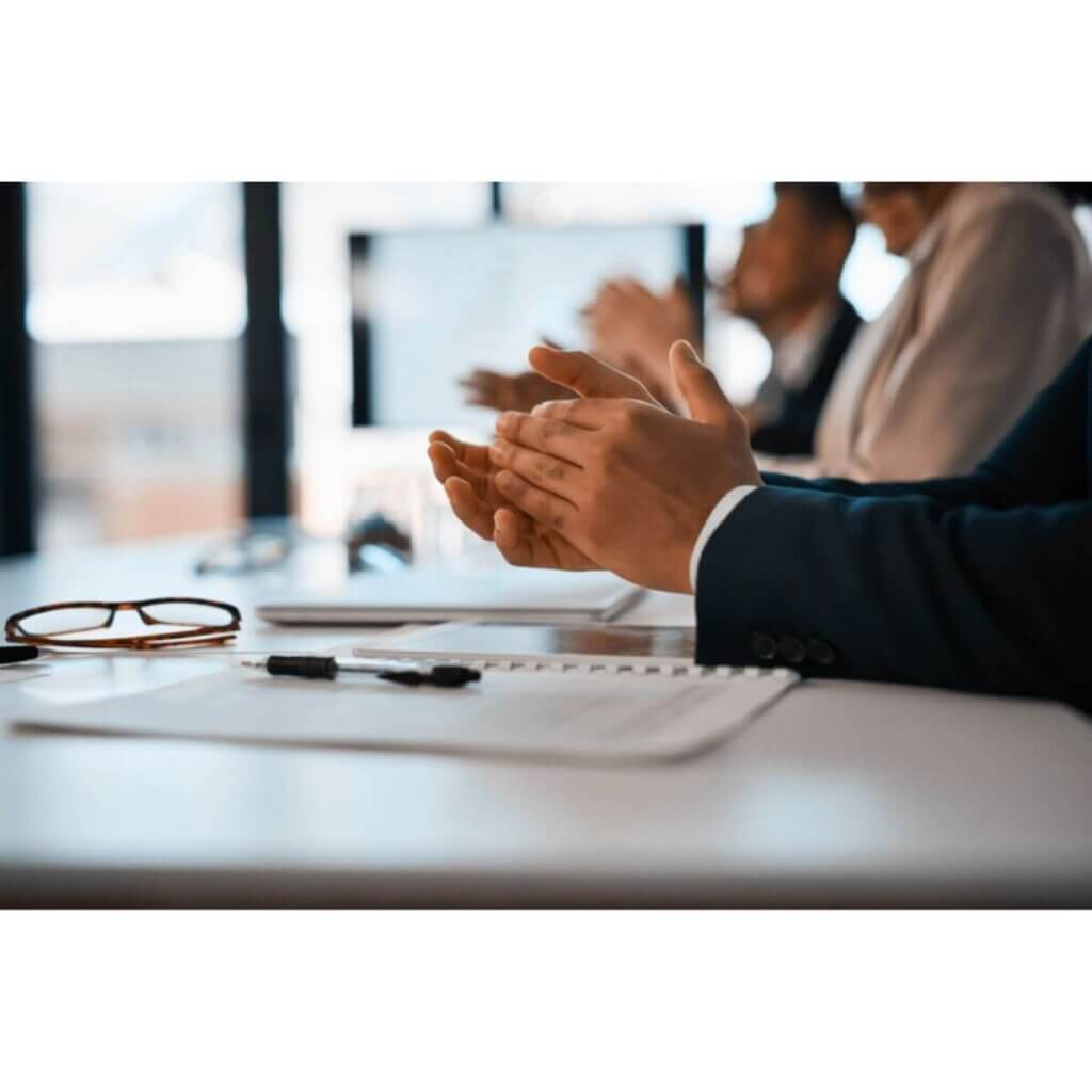 group of business people in conference room clapping